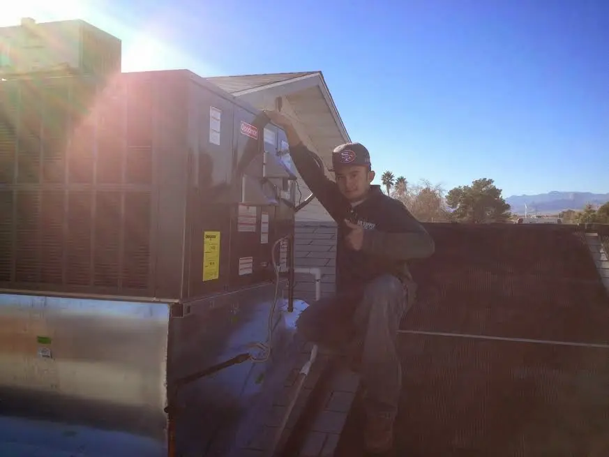 HVAC technician performing AC Tune-Up on a rooftop unit in Eastvale
